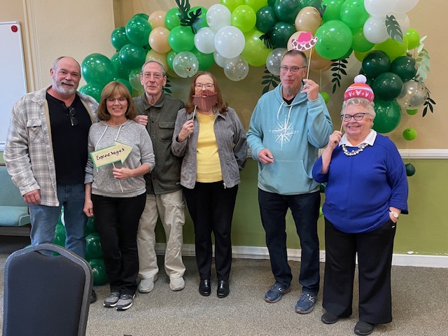 people sitting on chair in front of table while holding pens during daytime